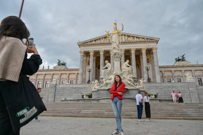 Beč, Austrija: Zgrada austrijskog parlamenta u Beču. Turisti se fotografišu ispred parlamenta. Ljudi na trgu.