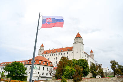 Zastava Slovačke se vijori ispred dvorca u Bratislavi. Zastava Slovačke na jarbolu. Državni grb Slovačke.