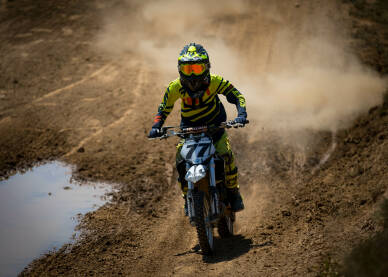 Vozač cross motora tokom trke. Motocross trka. Takmičenje u vožnji cross motora.