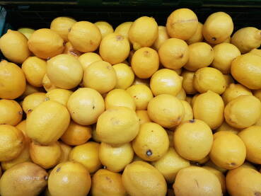Žuti svježi limun na polici u prodavnici; prodaja svježeg limuna;