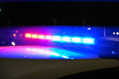 Policijska svjetla za bljeskaju noću u blizini automobilske nesreće. Saobraćajna policija. Crvena i plava svjetla na policijskom autu.