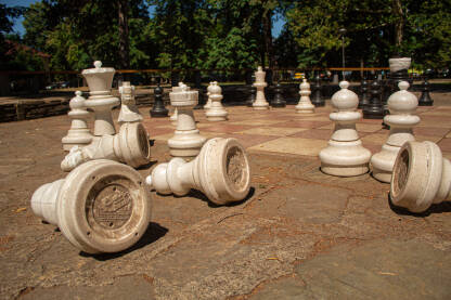 Šah u parku. Porušene bijele figure, šahofska tabla. Kraj igre, Šah-mat.