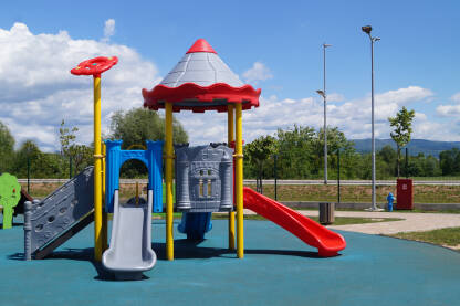 Parkovski mobilijar, park za djecu. igralište. Šareni plastični tobogani u dječijem parku na plavoj podlozi.