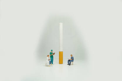 Cigareta sa figuricama doktora na bijeloj pozadini. Ovisnost o pušenju.