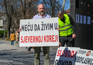 Muškarac drži transparent "Neću da živim u Sjevernoj Koreji", tokom protesta u Banjaluci, protiv kriminalizacije klevete u Republici Srpskoj. Suprotstavljanje režimu i represiji.