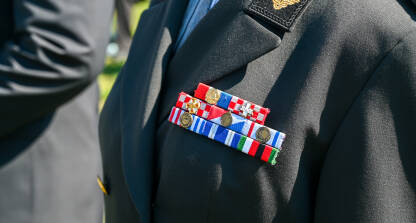 Medalje i značake na vojničkoj uniformi. Vojne medalje i vrpce, krupni plan. Svečana vojna priznanja na oficirskoj uniformi.