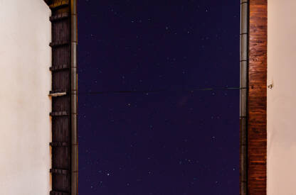 Pogled na zvjezdano nebo dok su dvije kuće spojene kablom