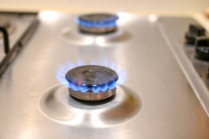 Plinski šporet u kuhinji. Plavi plamen na plinskom štednjaku u kući. Krupni plan vatre na plinskom štednjaku.