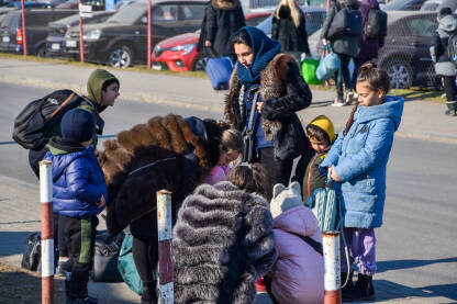 Žene i djeca na granici Ukrajina-Poljska. Ljudi iz Ukrajine bježe od rata. Žene i djeca nose kofere.