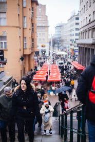 Ljudi šetaju kroz okićen grad za vrijeme adventa u Zagrebu.