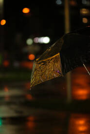 Refleksija svjetlosti na kišobranu uz kišu
