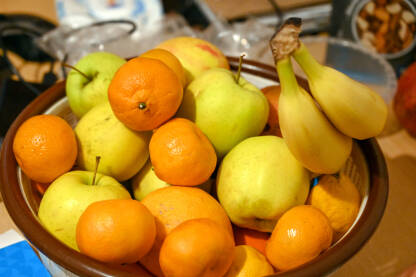 Zdjela puna voća. Narandže, jabuke, mandarine, banane.