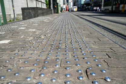Taktilne ploče na trotoara u gradu. Taktilni betonski blokovi za pomoć pješacima koji imaju oštećen vid.