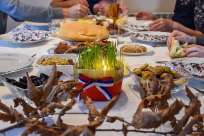 Porodica doručkuje na pravoslavni Božić. Božićna trpeza sa pečenicom, česnicom i drugom tradicionalnom hranom.
