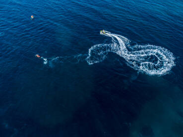Motorni čamac na moru, snimci dronom. Gliser na vodi. Turisti uživaju na izletu u čamcu.