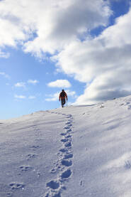 Planinar u zimskom usponu na planinu Vranicu iznad Prokoškog jezera.