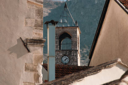 Mostarska "Sahat Kula" iz telefoto perspektive iza manjih kuća.