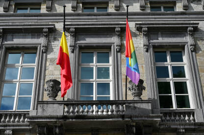 Belgijska i LGBT zastava na zgradi u Briselu, Belgija. LGBTIQ zastava ponosa pored belgijske zastave.