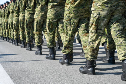 Vojnici u maskirnim uniformama i crnim čizmama marširaju u formaciji na paradi. Specijalne oružane snage.