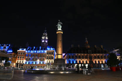 Lille, Francuska: Glavni trg ili Grand Place noću. Historijske zgrade u centru grada. Fontana, stup i spomen obilježje.
