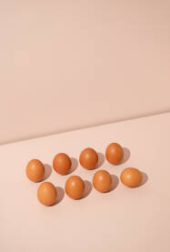 Osam svježih kokošijih jaja na pastelnoj pozadini.