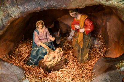 Scena jaslica koja prikazuje bebu Isusa Krista s Marijom, Josipom, anđelima i kraljevima u pećini. Rođenje Isusa Hrista. Kršćanstvo i religija. Božićni ukrasi u katedrali.