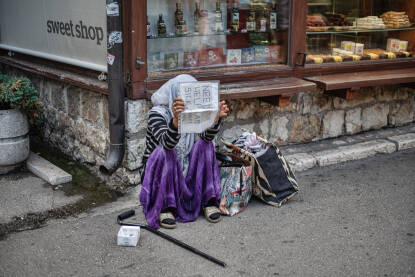 Starija žena na ulicama Sarajeva moli za pomoć.