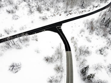 Raskrsnica na planini, snimak dronom. Put na planini okružen gustim snijegom i drvećem. Zima na planini Bjelašnici.