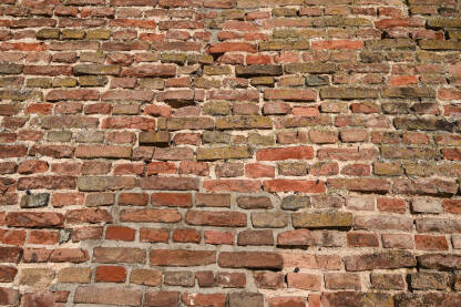 Zid od cigli. Stari zid od opeke na kući. Tekstura crvenih kamenih blokova, krupni plan.