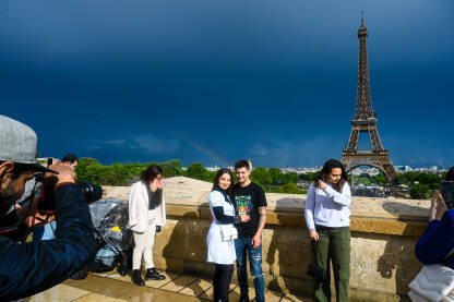 Pariz, Francuska: Turisti se fotografišu pored Ajfelovog tornja. Popularna turistička destinacija. Eiffel Tower.