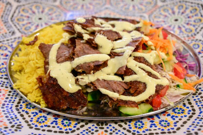Ukusan kebab serviran sa povrćem i rižom u restoranu. Tradicionalno jelo na tanjiru.
