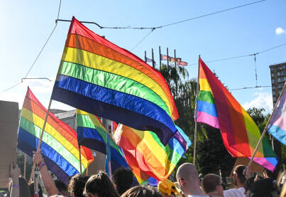 Povorka ponosa. LGBTIQ zastave na protestu. Ljudi mašu duginom LGBT zastavom. Simbol ljubavi i ljudskih prava.