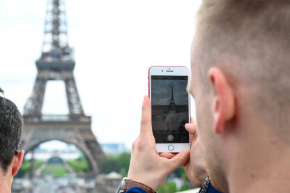 Pariz, Francuska: Turisti se fotografišu pored  Eiffelovog tornja. Popularno turističko odredište.
