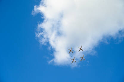 Grupa aviona koji lete u formaciji na aeromitingu. Četiri aviona lete u akrobatskoj formaciji.