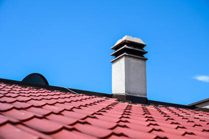 Crveni metalni crijep na krovu kuće. Krov od limova.