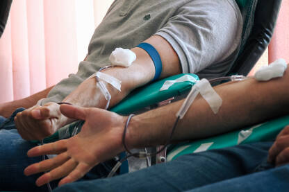 Dobrovoljni davaoci krvi daruju krv. Krupni plan ruku u procesu darivanja krvi.