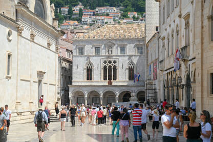 Dubrovnik, Hrvatska: Grupa turista u starom gradu. Dubrovnik, Hrvatska: Grupa turista u starom gradu. Ljudi šetaju centrom grada. Stare zidine i zgrade u Dubrovniku. Popularno turističko odredište na Jadranskom moru. Stradun.