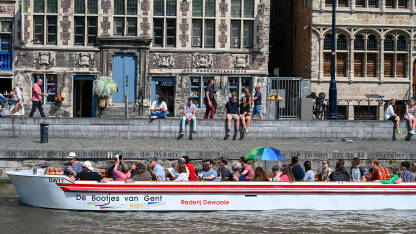 Ghent, Belgija. Turisti u čamcima istražuju grad. Ghent, Belgija. Turisti u čamcima istražuju grad. Historijske zgrade i rijeka u gradu.