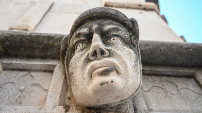 Šibenik, Hrvatska: Skulptura čovjekovog lica na katedrali. Drevne kamene figure. Detalj glave muške skulpture.