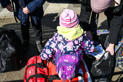 Dijete izbjeglica. Izbjeglice iz Ukrajine bježe od rata. Ukrajinske izbjeglice na prelasku granice sa Poljskom. Ukrajinci bježe od rata.