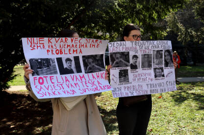 Dvije mlade žene drže transparente s fotografijama i porukama tražeći pravdu tokom protesta u Sarajevu