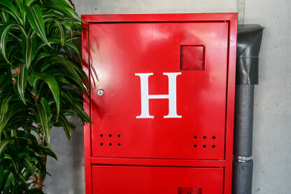 Kutija s vatrogasnim hidrantom u zgradi. Hidrant za vodu i vatrogasna crijeva unutar crvene metalne kutije. Oprema u slučaju požara.