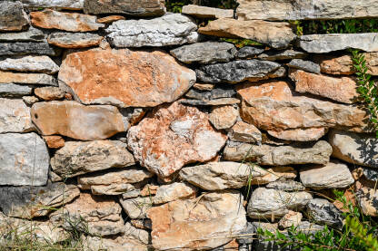 Suhozid, krupni plan. Kameni zid kraj kuće na selu. Tradicionalni suhozid u polju