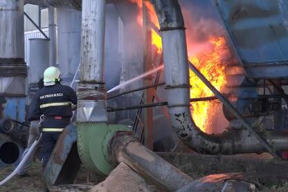 Vatrogasac gasi požar na fabričkom postrojenju.