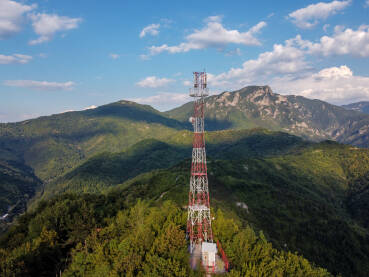 GSM i radio telekomunikacioni toranj na vrhu brda. Predajnik mobilnih operatera, snimak dronom iz zraka. Bazna primopredajna stanica. Bežični komunikacioni antenski predajnik.
​