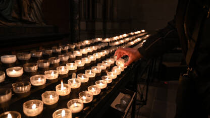 Vjernik pali svijeću u crkvi.