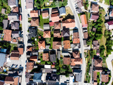 Snimci dronom na stambene kuće sa crvenim krovovima i na ulice sa parkiranim automobilima u gradu. Krovovi kuća i zgrada u gradu.