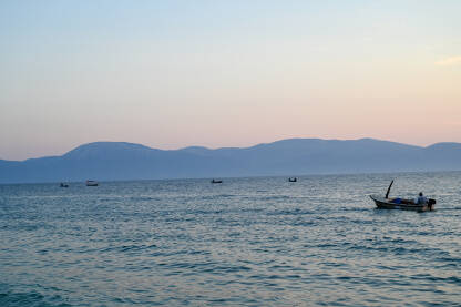 Grupa ribarskih čamaca na moru u predvečerje. Ribolov. Čamci na vodi.