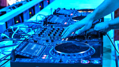 DJ pušta muziku sa opremom na festivalu. Profesionalni CD plejer i mikser zvuka. DJ u noćnom klubu.