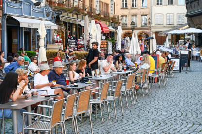 Strazbur, Francuska: Ljudi sjede i piju piće u kafiću. Turisti na ručku u restoranu.